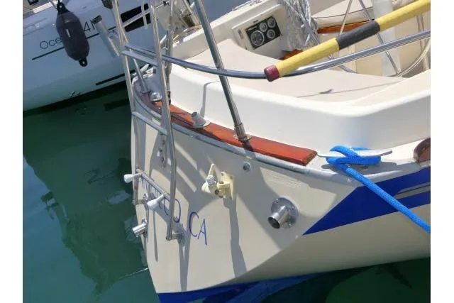 Slide: The Image of Stern view of a 1978 Tartan 37 sailboat docked, featuring a ladder and blue rope. - 49
