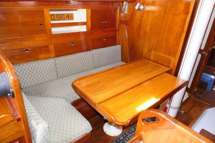 Slide: The Image of Interior of a 1978 Tartan 37 sailboat with wooden dining area and cushioned seating. - 5