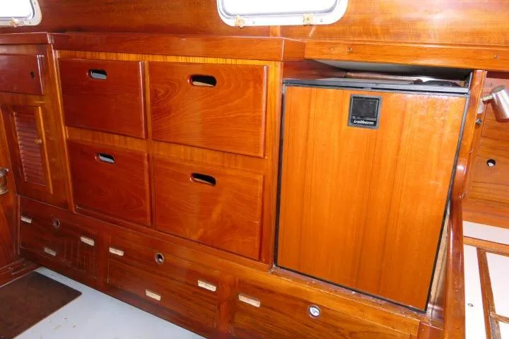 Slide: The Image of Interior of a 1978 Tartan 37 sailboat with wooden cabinetry and built-in refrigerator. - 8