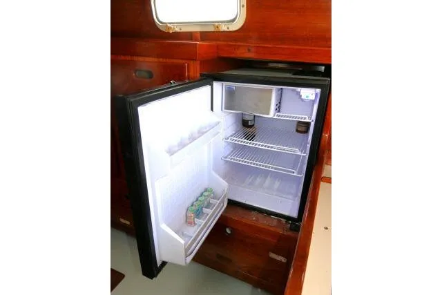 Slide: The Image of Open refrigerator inside a 1978 Tartan 37 yacht, showcasing interior storage and beverages. - 9