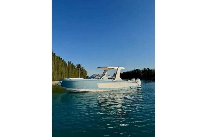 Slide: The Image of 2024 Aviara AV28 OB boat on calm water under clear blue sky. - 2