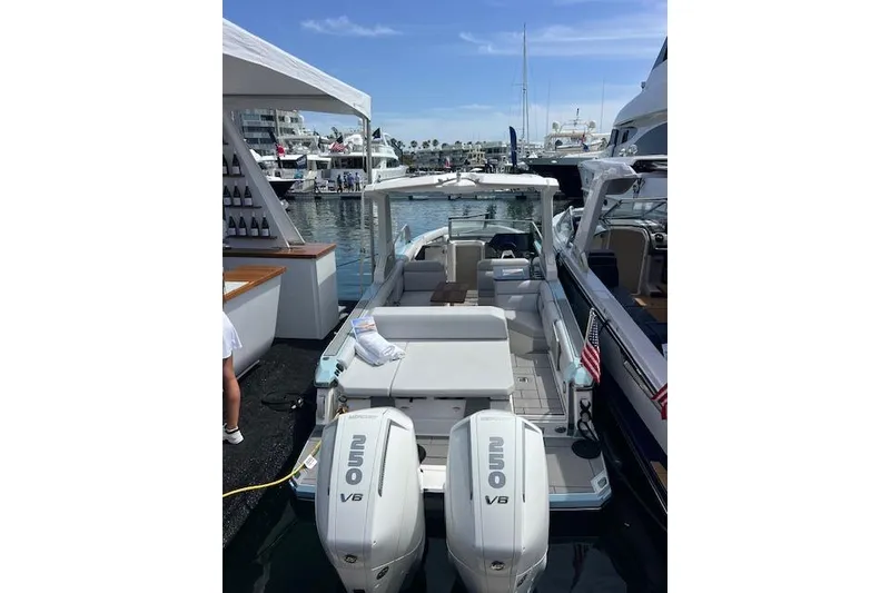 Slide: The Image of 2024 Aviara AV28 OB boat with dual outboard engines docked at a marina. - 5
