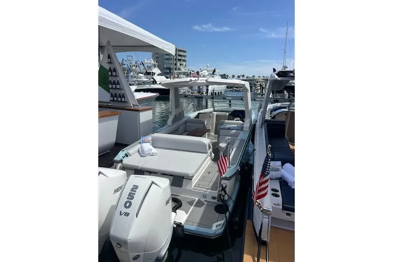 Slide: The Image of 2024 Aviara AV28 OB luxury boat docked, featuring spacious seating and twin Mercury V8 engines. - 6