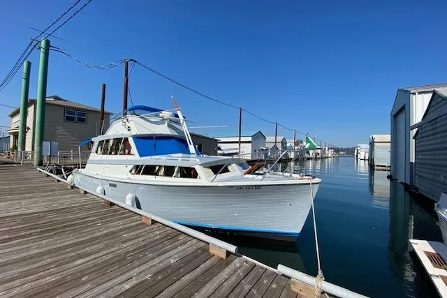The Image of 1964 Pacemaker Flybridge Cruise boat docked at a marina under clear blue skies. - 0