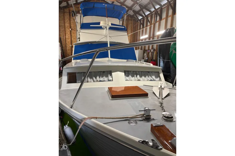 Slide: The Image of 1964 Pacemaker Flybridge Cruise boat with blue canopy, docked indoors. - 10