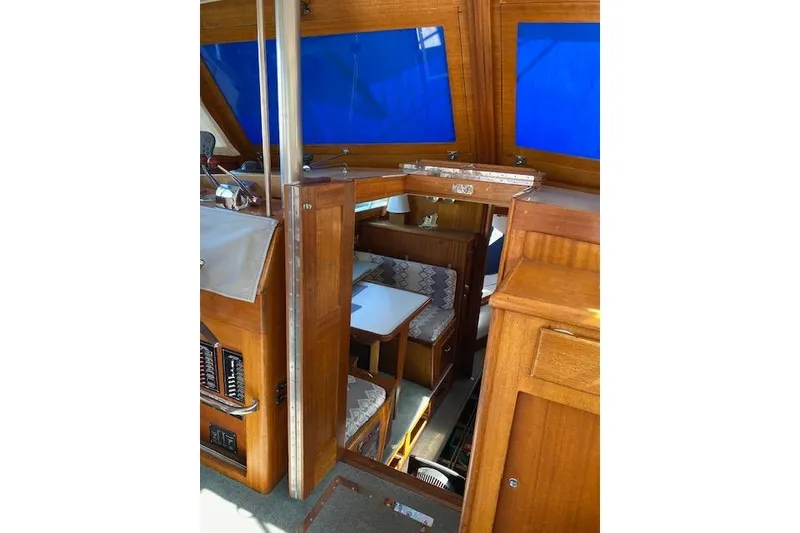 Slide: The Image of Interior of a 1964 Pacemaker Flybridge cruise boat with wooden furnishings and blue windows. - 13