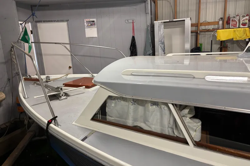 Slide: The Image of 1964 Pacemaker Flybridge Cruise boat in indoor storage, showcasing deck and cabin details. - 2