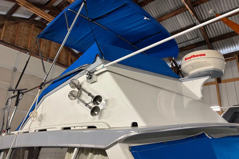 Slide: The Image of 1964 Pacemaker Flybridge Cruise boat with blue canopy and Raytheon radar in a wooden boathouse. - 4