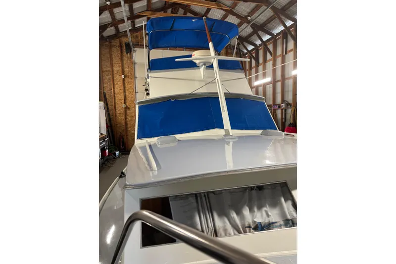Slide: The Image of 1964 Pacemaker Flybridge Cruise boat with blue canopy, stored indoors. - 6