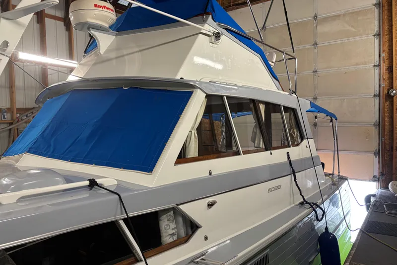 Slide: The Image of 1964 Pacemaker Flybridge Cruise boat with blue canopy in a garage setting. - 8