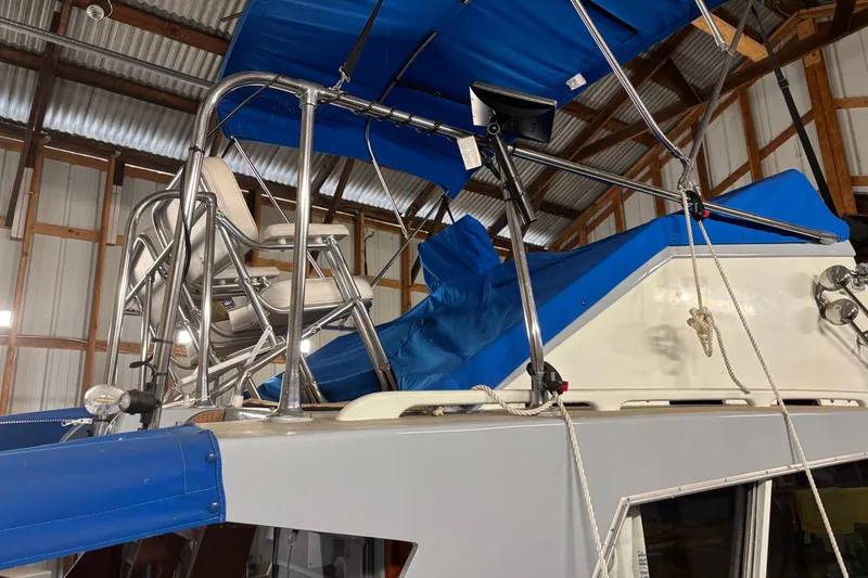 Slide: The Image of 1964 Pacemaker Flybridge Cruise with blue canopy and seating in a wooden boathouse. - 9