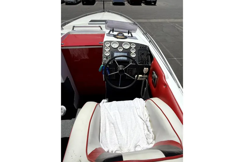 Slide: The Image of 1979 Charger 30 Cuddy boat cockpit with red and white seating, steering wheel, and dashboard controls. - 16