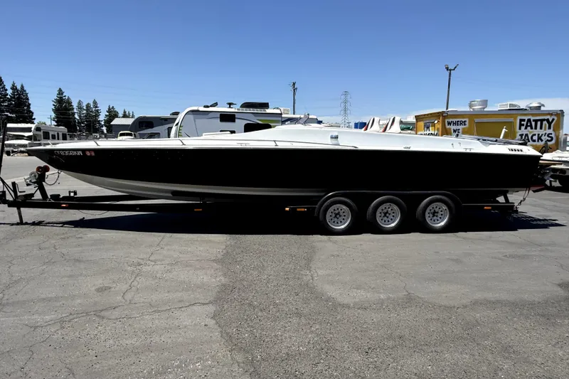 Slide: The Image of 1979 Charger 30 Cuddy boat on trailer in parking lot, side view. - 17