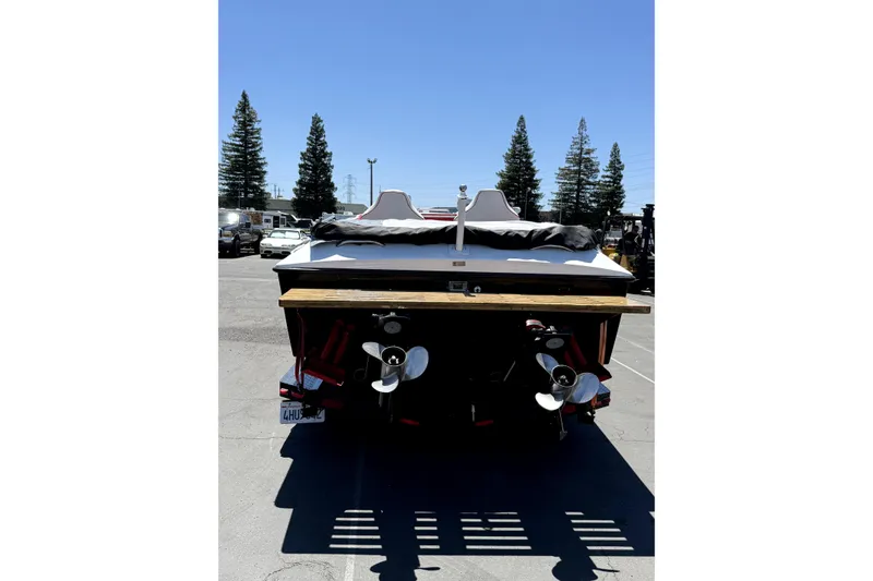 Slide: The Image of Rear view of a 1979 Charger 30 Cuddy boat with dual propellers in a parking lot. - 9