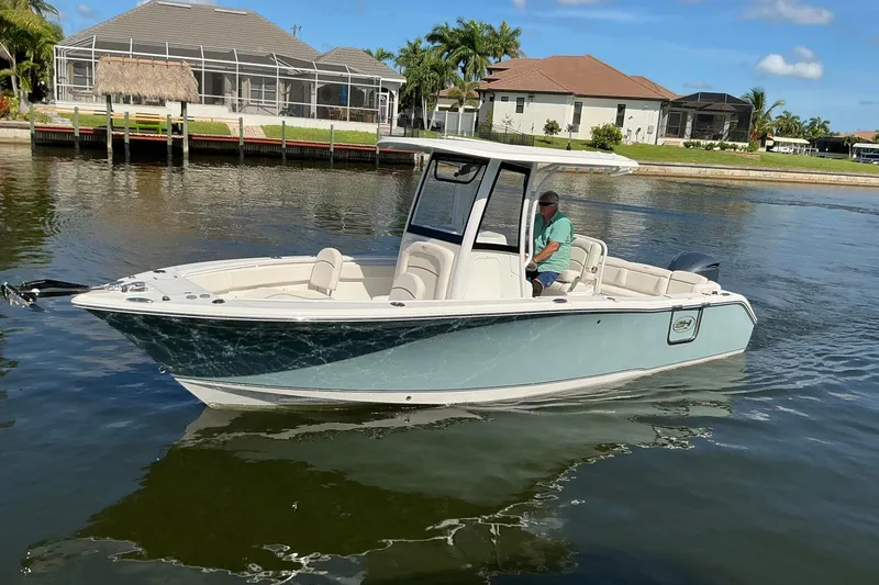 Slide: The Image of 2019 Sea Hunt Ultra 255 SE boat on calm water. - 1
