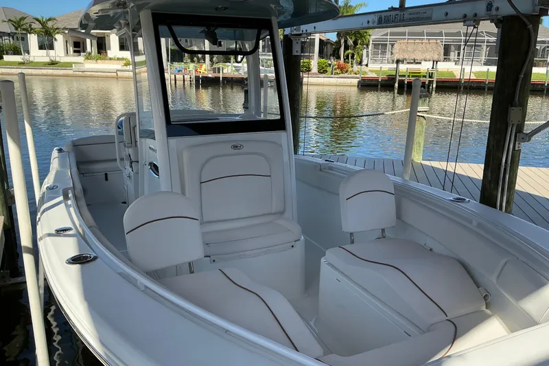Slide: The Image of 2019 Sea Hunt Ultra 255 SE boat docked, showcasing spacious seating and sleek design. - 10