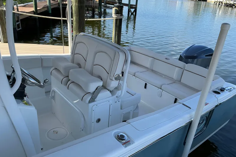 Slide: The Image of 2019 Sea Hunt Ultra 255 SE boat interior with seating and steering wheel by the dock. - 11