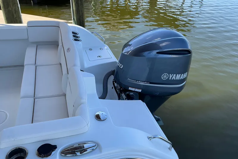 Slide: The Image of 2019 Sea Hunt Ultra 255 SE boat with Yamaha outboard motor, docked on calm water. - 14