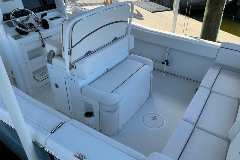 Slide: The Image of 2019 Sea Hunt Ultra 255 SE boat interior with white seating and steering console. - 17