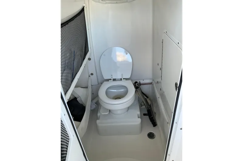 Slide: The Image of 2019 Sea Hunt Ultra 255 SE boat interior with compact marine toilet. - 21