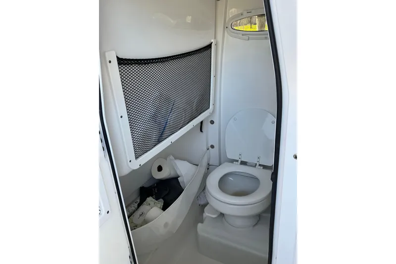 Slide: The Image of 2019 Sea Hunt Ultra 255 SE boat bathroom with toilet and storage net. - 22