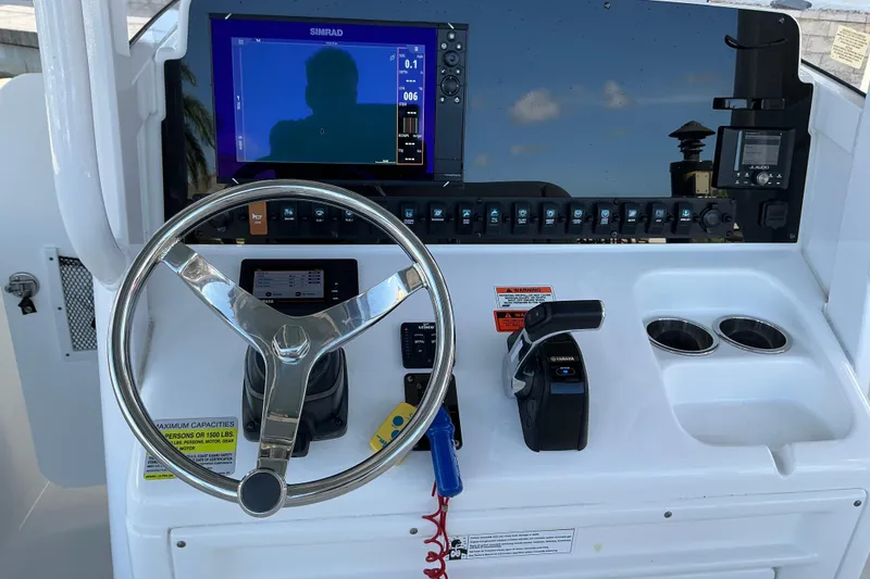 Slide: The Image of 2019 Sea Hunt Ultra 255 SE boat dashboard with steering wheel and control panel. - 25