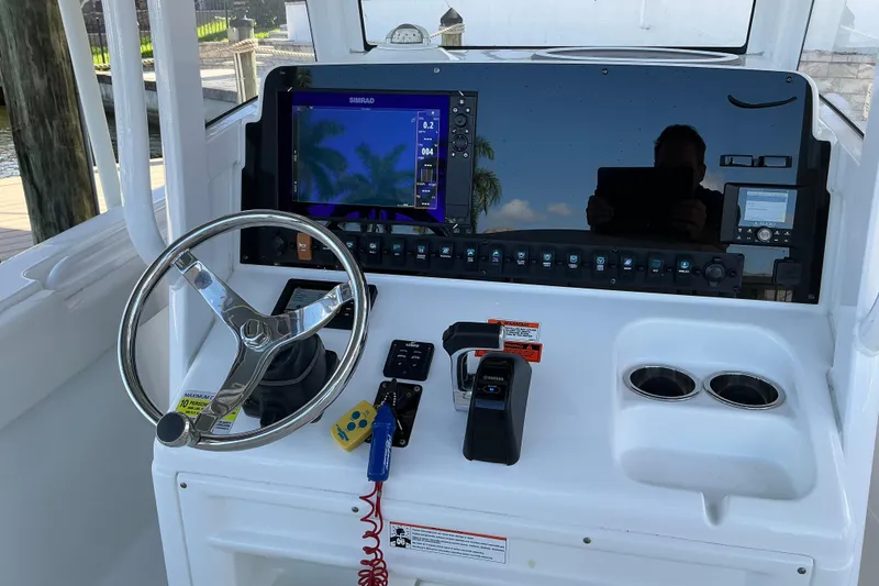 Slide: The Image of 2019 Sea Hunt Ultra 255 SE boat dashboard with steering wheel and navigation controls. - 26