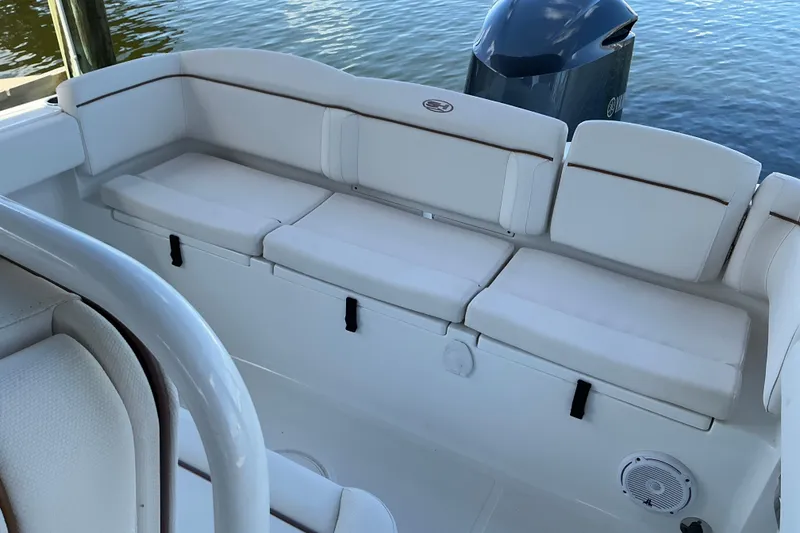 Slide: The Image of 2019 Sea Hunt Ultra 255 SE boat with white cushioned seating and outboard motor. - 27