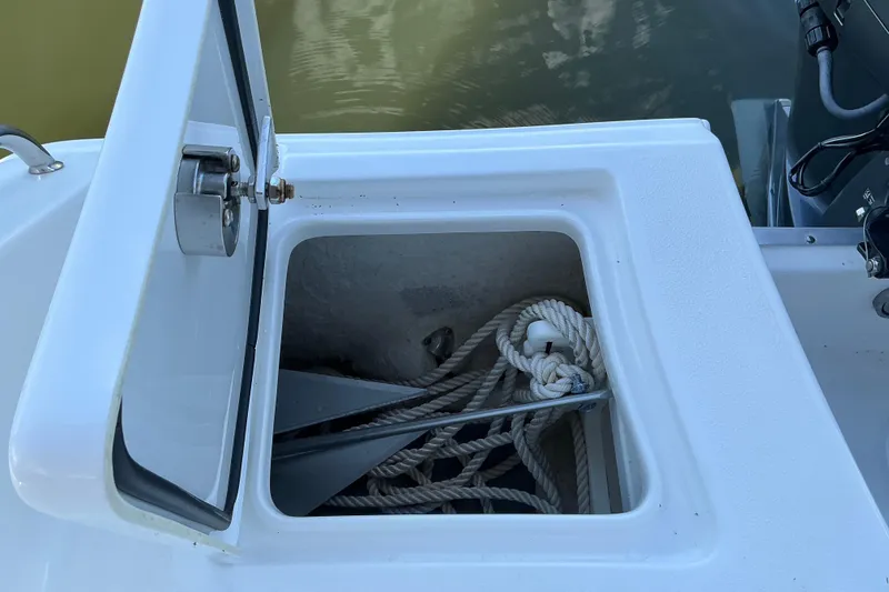Slide: The Image of Open storage compartment on 2019 Sea Hunt Ultra 255 SE boat with ropes and anchor. - 30