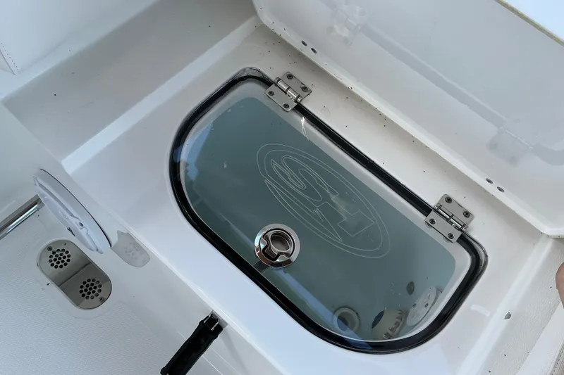 Slide: The Image of Livewell compartment on a 2019 Sea Hunt Ultra 255 SE boat, featuring a transparent lid. - 34