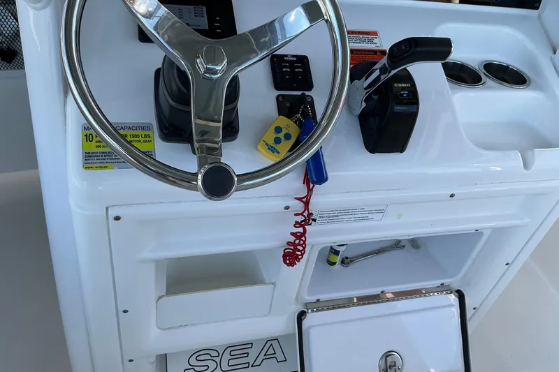 Slide: The Image of Steering console of a 2019 Sea Hunt Ultra 255 SE boat with controls and storage. - 36