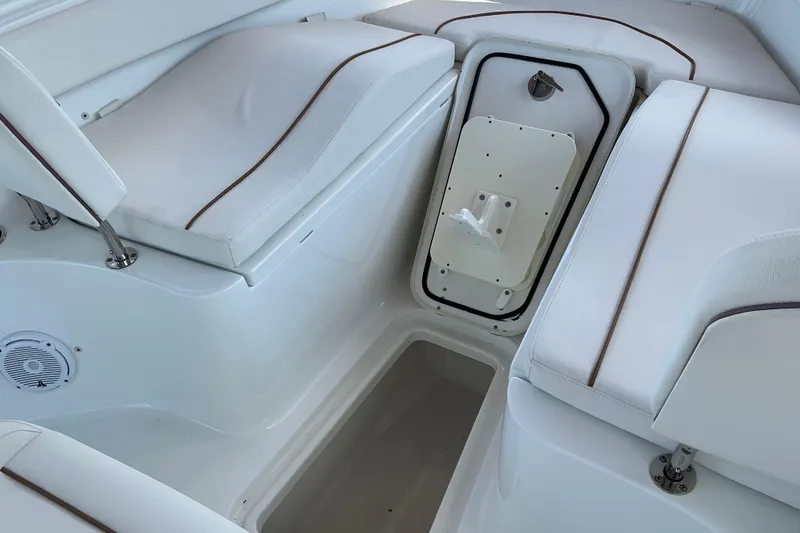Slide: The Image of 2019 Sea Hunt Ultra 255 SE boat interior with white cushioned seating and storage compartment. - 40
