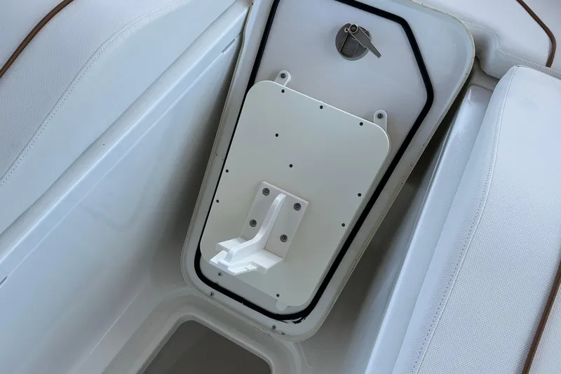Slide: The Image of 2019 Sea Hunt Ultra 255 SE boat storage compartment with secure latch and white interior. - 41