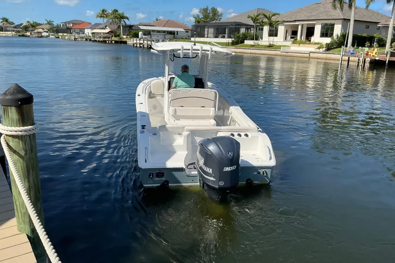 Slide: The Image of 2019 Sea Hunt Ultra 255 SE boat cruising in a scenic waterfront neighborhood. - 49
