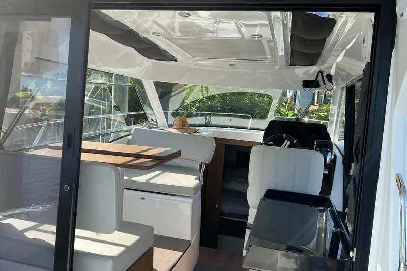 Slide: The Image of Interior view of 2022 Beneteau Antares 9 boat, featuring seating and helm area. - 10