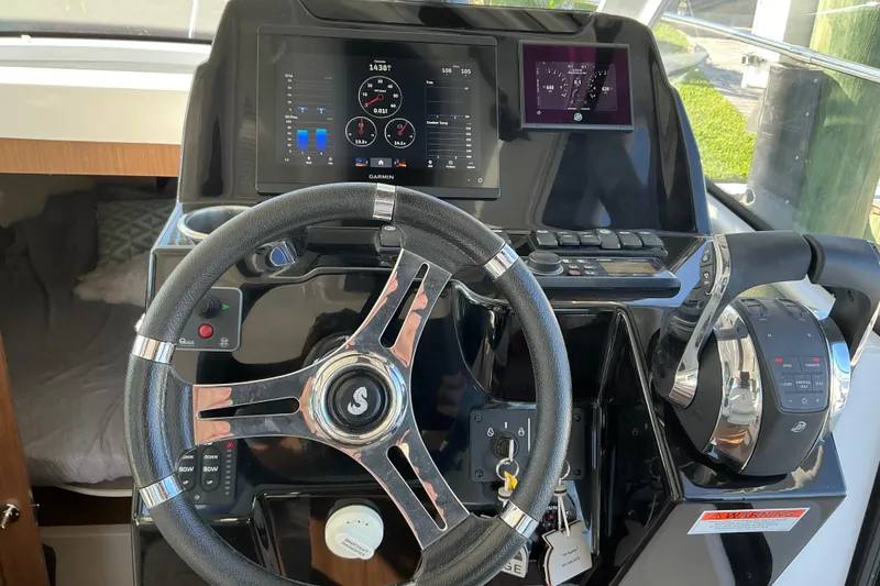 Slide: The Image of Cockpit of 2022 Beneteau Antares 9 with steering wheel and navigation displays. - 12