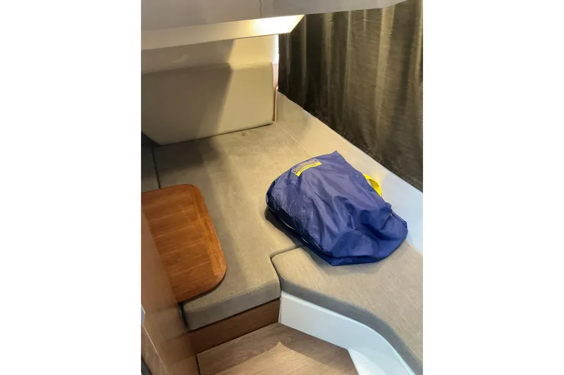 Slide: The Image of Interior cabin of 2022 Beneteau Antares 9 with seating and a blue bag. - 17