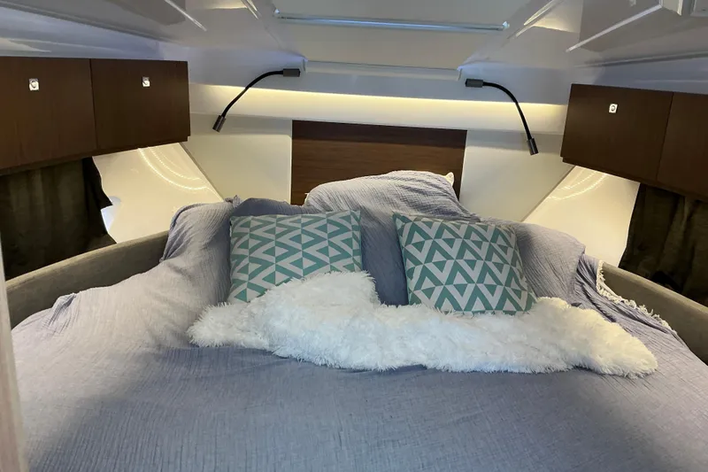 Slide: The Image of Cozy cabin interior of 2022 Beneteau Antares 9 with plush bedding and geometric pillows. - 20
