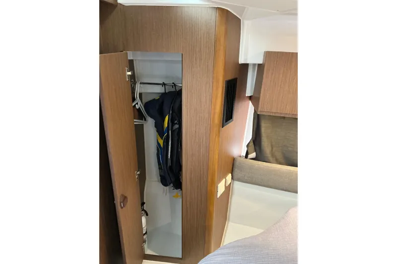 Slide: The Image of Interior closet of 2022 Beneteau Antares 9 boat with hanging jackets. - 21