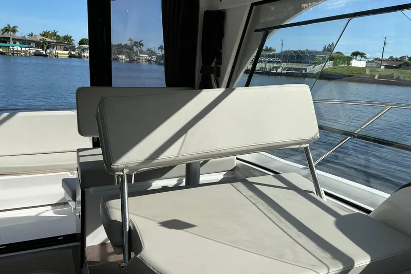Slide: The Image of Interior view of 2022 Beneteau Antares 9 boat with seating and waterfront backdrop. - 23