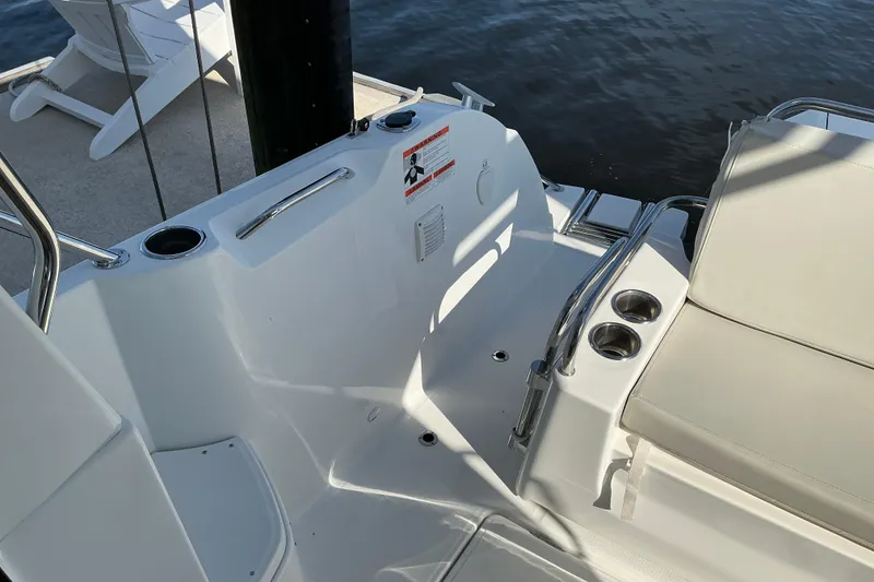 Slide: The Image of 2022 Beneteau Antares 9 boat deck with seating and cup holders, docked by the water. - 24
