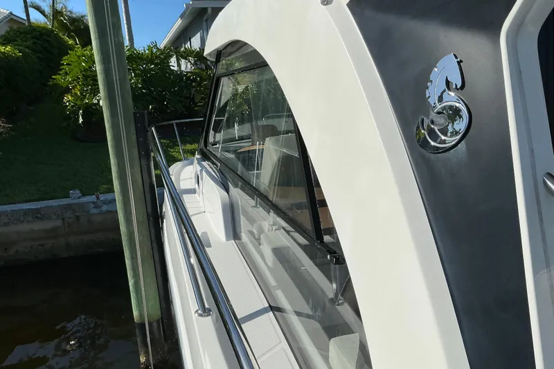 Slide: The Image of 2022 Beneteau Antares 9 boat docked, showcasing sleek design and chrome detailing. - 30