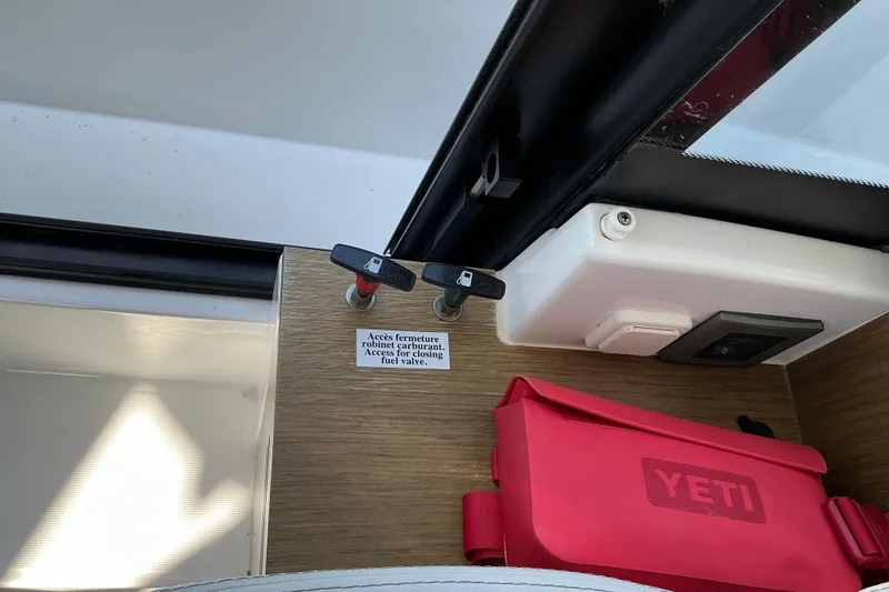 Slide: The Image of Fuel valve access on 2022 Beneteau Antares 9 boat, with red Yeti bag nearby. - 33