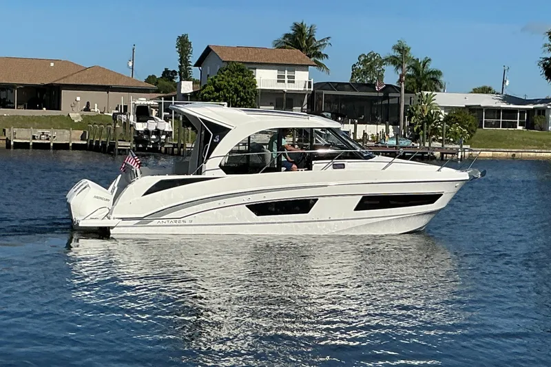 Slide: The Image of 2022 Beneteau Antares 9 motorboat cruising on a sunny day near waterfront homes. - 46