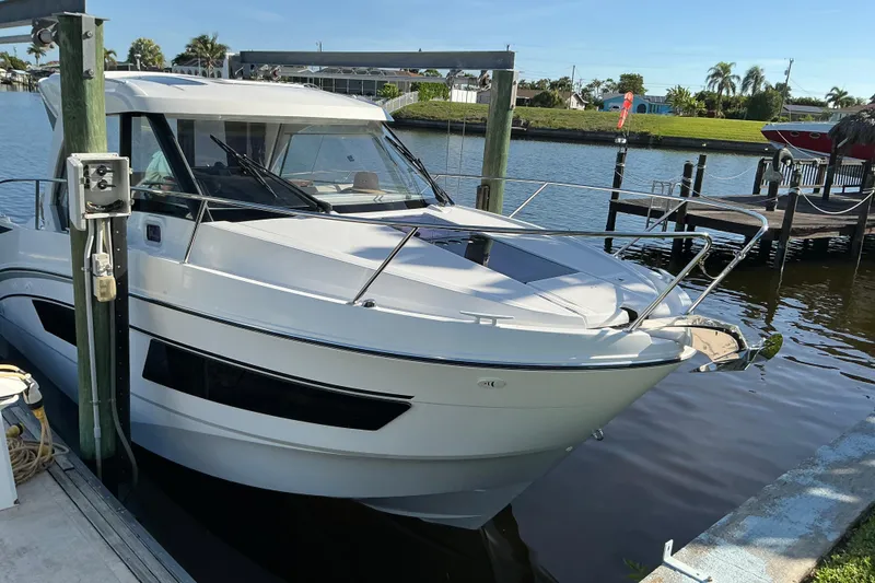 Slide: The Image of 2022 Beneteau Antares 9 docked at a marina, surrounded by calm water and greenery. - 5