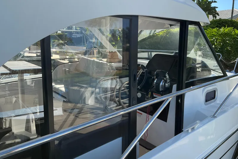 Slide: The Image of 2022 Beneteau Antares 9 boat interior with steering wheel and controls, docked outdoors. - 6