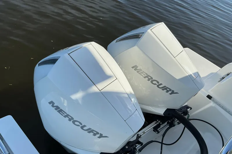 Slide: The Image of Twin Mercury outboard engines on a 2022 Beneteau Antares 9 boat, docked on calm water. - 8