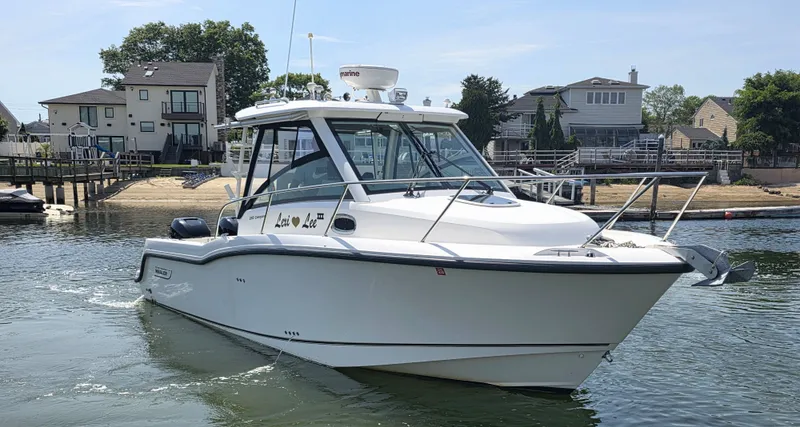 Slide: The Image of 2016 Boston Whaler 285 Conquest boat on water near houses. - 2
