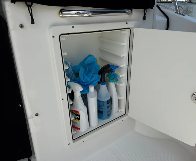 Slide: The Image of Storage compartment with cleaning supplies on 2016 Boston Whaler 285 Conquest. - 21