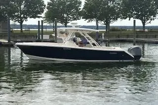 The Image of 2014 Pursuit S 280 Sport boat docked in a serene marina setting. - 1